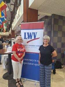 Two League members by a LWV banner